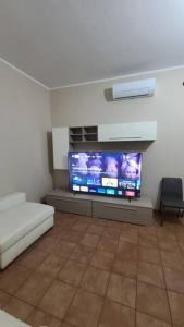 uma sala de estar com uma grande televisão de ecrã plano em Casa vacanze palagianello em Palagianello