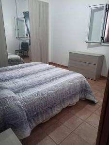 um quarto com uma cama com um cobertor em Casa vacanze palagianello em Palagianello