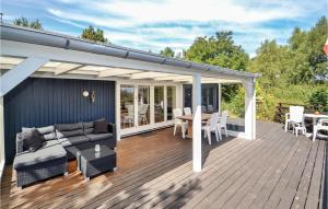 eine Terrasse mit einem Sofa und einem Tisch auf einer Terrasse in der Unterkunft Stunning Home In Ebeltoft With Wifi in Ebeltoft
