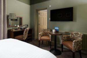 アンブルサイドにあるLakehouse at The Waterhead Innのベッド、テーブル、椅子が備わるホテルルームです。