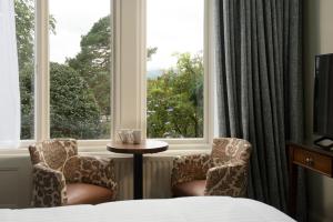 una habitación de hotel con 2 sillas y una ventana en Lakehouse at The Waterhead Inn en Ambleside