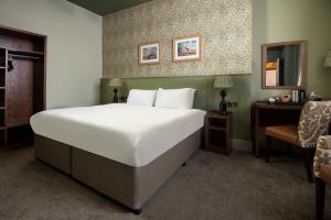 a bedroom with a large white bed and a chair at Lakehouse at The Waterhead Inn in Ambleside