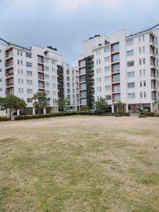 a large grass field in front of tall buildings at Cozzy homestyle in Nairobi