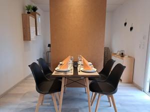 a dining room with a wooden table and black chairs at FiMo-Haus in Nagel