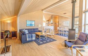 YderbyにあるAwesome Home In Sjllands Odde With 3 Bedrooms, Sauna And Wifiのリビングルーム(青いソファ、テーブル付)
