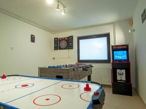 a room with a ping pong table and a video game at Holiday house Zarja - with sauna and hot tub in Bizeljsko