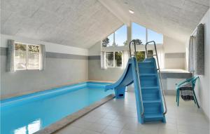 AsserboにあるBeautiful Home In Frederiksvrk With Wifi, Indoor Swimming Pool And Outdoor Swimming Poolの家屋内の青い滑り台付きスイミングプール