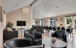 a waiting room with chairs and tables and a television at Cozy Home In Frederiksværk With Sauna in Asserbo