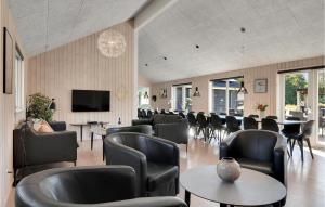 a waiting room with chairs and tables and a television at Beautiful Home In Frederiksvrk With Kitchen in Asserbo