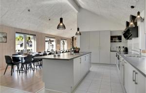 a kitchen and dining room with a table and chairs at Cozy Home In Frederiksværk With Sauna in Asserbo