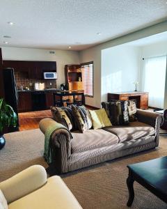 sala de estar con sofá y cocina en Cochrane’s Finest Airbnb, en Cochrane