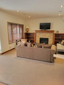 sala de estar con 2 sofás y chimenea en Cochrane’s Finest Airbnb, en Cochrane