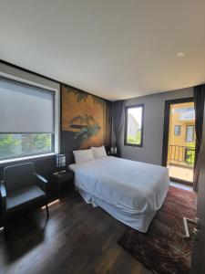 sypialnia z dużym białym łóżkiem i oknem w obiekcie Miyabi Wyndham Thanh Thuỷ w mieście Phú Thọ