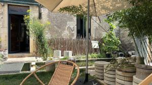 eine Terrasse mit einem Stuhl und einem Sonnenschirm in der Unterkunft Maison au bord de l’eau in Annay-sur-Serein