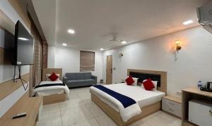 ハイデラバードにあるFabHotel Prime Anika Suitesのベッドとソファ付きのホテルルーム