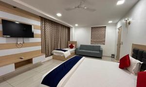 a hotel room with a bed and a tv at FabHotel Prime Anika Suites in Hyderabad