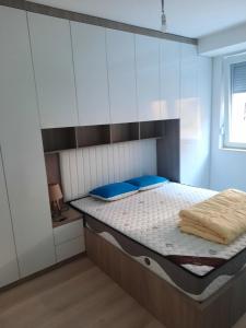 Un dormitorio con una cama con almohadas azules. en Apartment Dastidi en Kosovo Polje