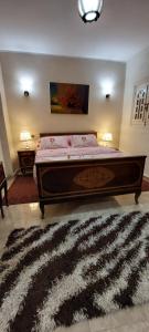 a bedroom with a large bed with a black and white rug at Hello Pyramids inn in Cairo