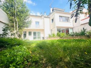 a large white house with a grass yard at Reims Sherpa Guest House in Reims