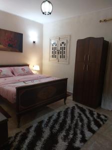 a bedroom with a large bed and a dresser at Hello Pyramids inn in Cairo