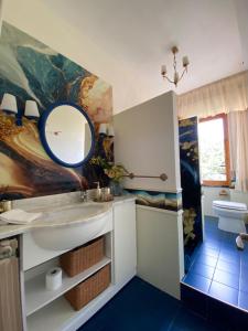 ein Bad mit einem Waschbecken und einem Wandspiegel in der Unterkunft Rosymarty Apartment-vicino Firenze in Prato
