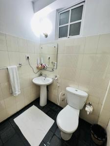 a bathroom with a toilet and a sink at Embrace "The Fine Stay" in Nuwara Eliya