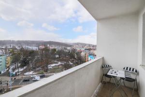 a balcony with two chairs and a view of a city at Apartment Park de Gaulle Gdansk Wrzeszcz by Renters in Gdańsk