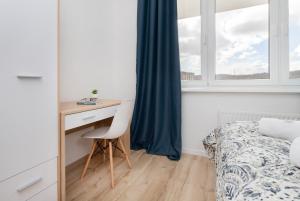 a bedroom with a desk and a bed and a desk with a chair at Apartment Park de Gaulle Gdansk Wrzeszcz by Renters in Gdańsk