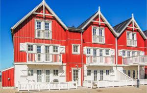 - un grand bâtiment rouge et blanc avec des balcons blancs dans l'établissement 2 Bedroom Cozy Apartment In Bagenkop, à Bagenkop