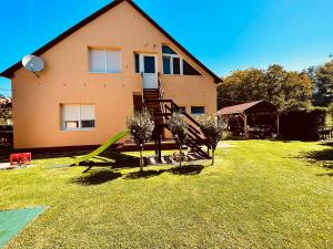 a house with a green lawn in front of it at Emília Apartment in Balatonföldvár