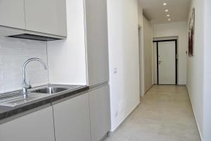 a kitchen with white cabinets and a sink and a hallway at Brezza di mare appartamento fronte spiaggia in Formia +57 photos