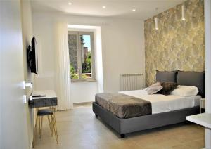 Schlafzimmer mit einem Bett, einem Schreibtisch und einem Fenster in der Unterkunft Brezza di mare appartamento fronte spiaggia in Formia