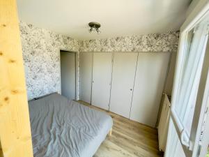ein kleines Schlafzimmer mit weißen Schränken und einem Bett in der Unterkunft Studio 43aJJ in Lure
