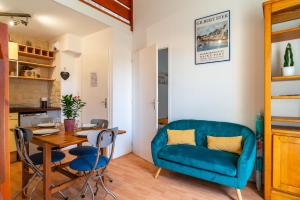 a living room with a blue couch and a table at Glazik - Appartement à 5 min de la plage in Saint-Nic