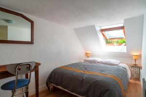 Glazik - Appartement à 5 min de la plage في Saint-Nic: غرفة نوم بسرير ومكتب ومرآة