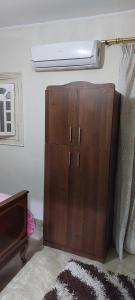 a wooden cabinet in a room with a light at Hello Pyramids inn in Cairo