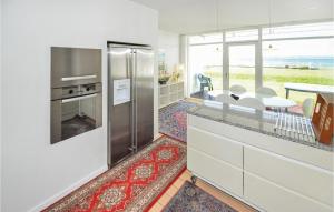 cocina con nevera de acero inoxidable y mesa en 2 Bedroom Awesome Apartment In Ebeltoft, en Ebeltoft