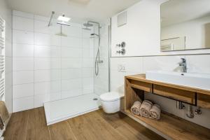 een badkamer met een wastafel, een douche en een toilet bij Haus Bergwelten in Bischofswiesen