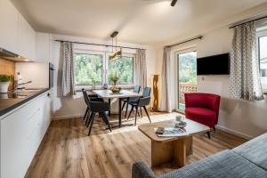 eine Küche und ein Wohnzimmer mit einem Tisch und Stühlen in der Unterkunft Haus Bergwelten in Bischofswiesen