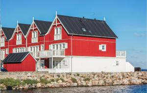 czerwono-biały budynek z czarnym dachem w obiekcie Awesome Apartment In Bagenkop With 3 Bedrooms, Sauna And Wifi w mieście Bagenkop