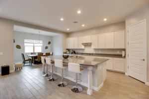 a kitchen with white cabinets and a table with chairs at Pet-Friendly Marana Home Community Pool and Hot Tub in Marana