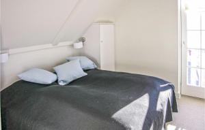una camera con un letto con due cuscini blu di Beach Front Apartment In Bagenkop With Kitchen a Bagenkop