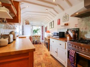 a large kitchen with white cabinets and a stove at 22 Church Ponds in Halstead