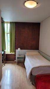 1 dormitorio con 1 cama y 1 mesa con lámpara en Nydeck en Berna