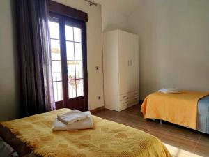 a bedroom with two beds and a large window at Encantos de Cazorla in Cazorla
