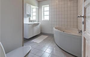 a white bathroom with a tub and a sink at Gorgeous Home In Slagelse With Wifi in Slagelse