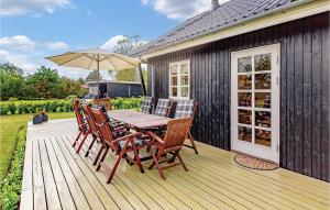 een houten terras met een tafel en stoelen en een parasol bij Gorgeous Home In Slagelse With Wifi in Slagelse