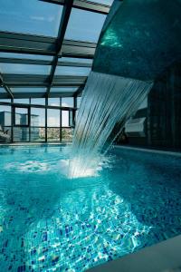 una piscina con una fuente de agua en un edificio en Hotel Prishtina en Pristina
