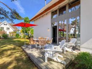una terraza con mesa, sillas y sombrilla en Ferienhaus Reethus 54° Loddin en Loddin