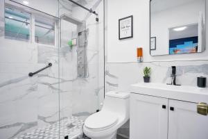 een witte badkamer met een toilet en een wastafel bij Vacay Spot Happy Escape 15 Min Beach Massage Shower Prime LOC! 6 blocks away from Bars, Nite Clubs, Res, Shops in Miami